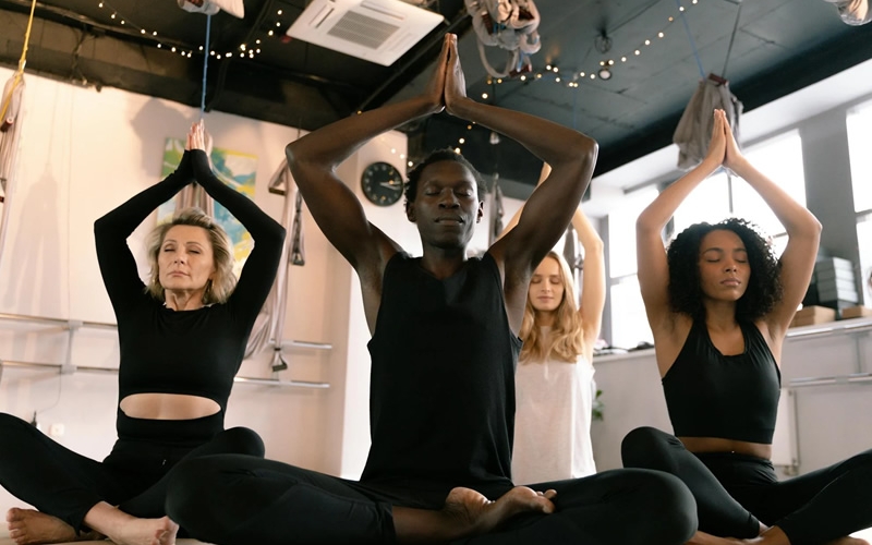 Group seated on floor, stretching in yoga class