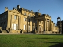 Broughton Hall, large stone building with columns at front and an expanse of green lawn.